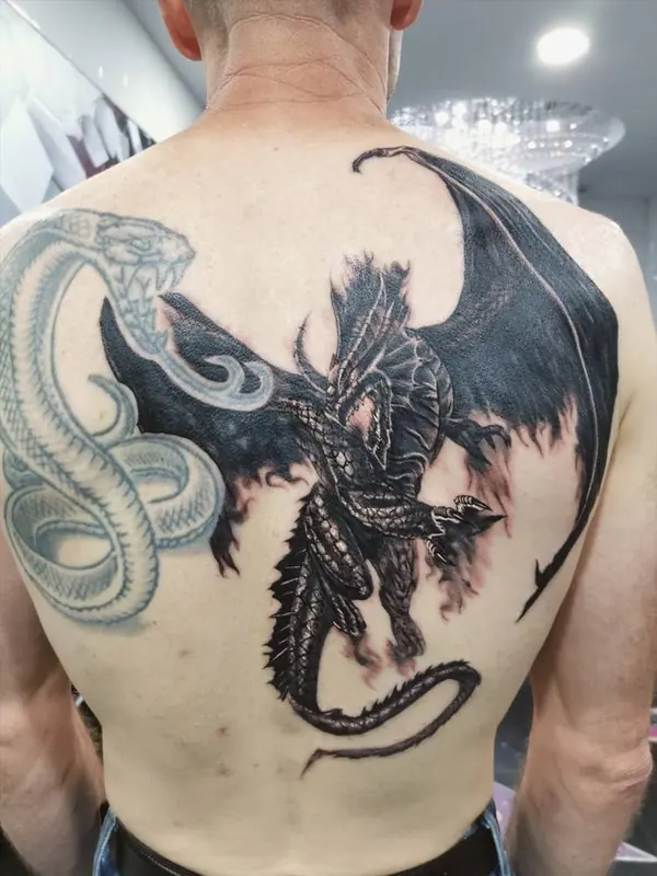 Black and grey dragon and snake back piece tattoo by Gwen, Pattaya