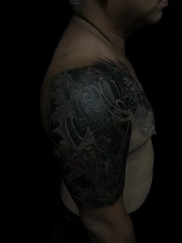 Dark cover-up tattoo on the shoulder by Gwen, Pattaya