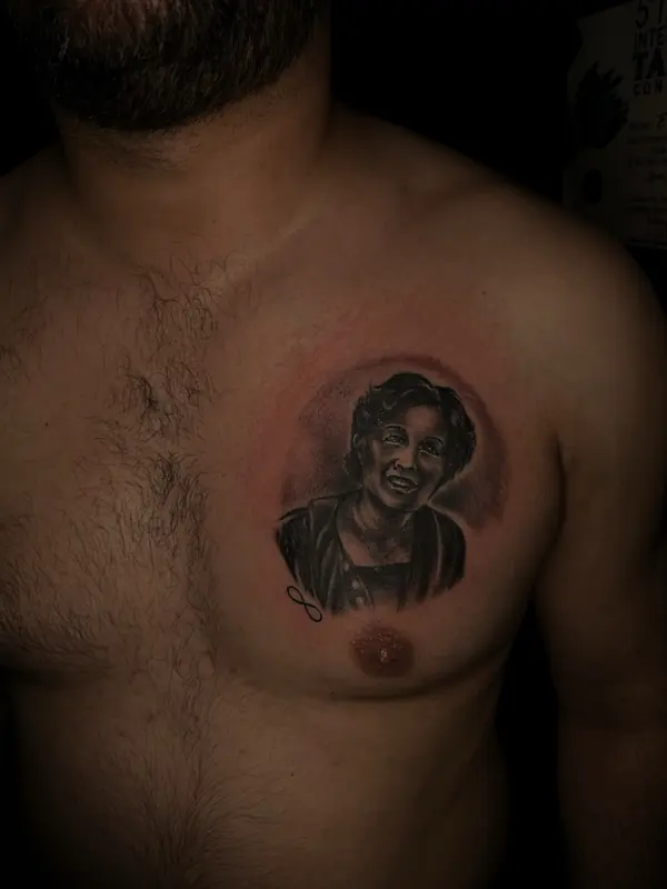 Realism tattoo by Gwen — small memorial portrait tattoo, black and grey